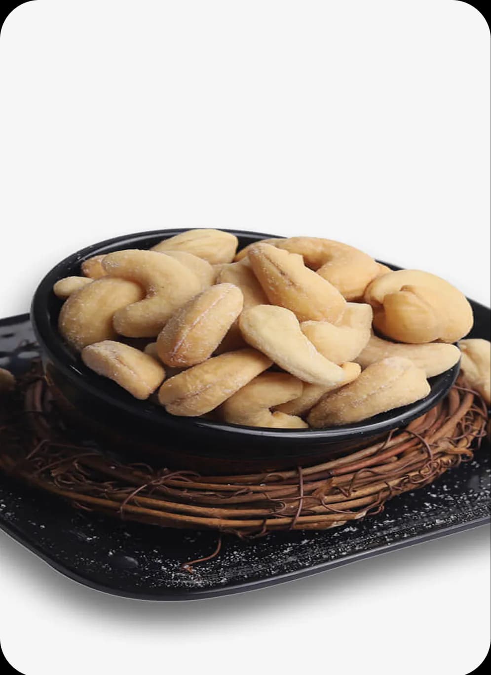 Bowl of roasted cashews on a black plate