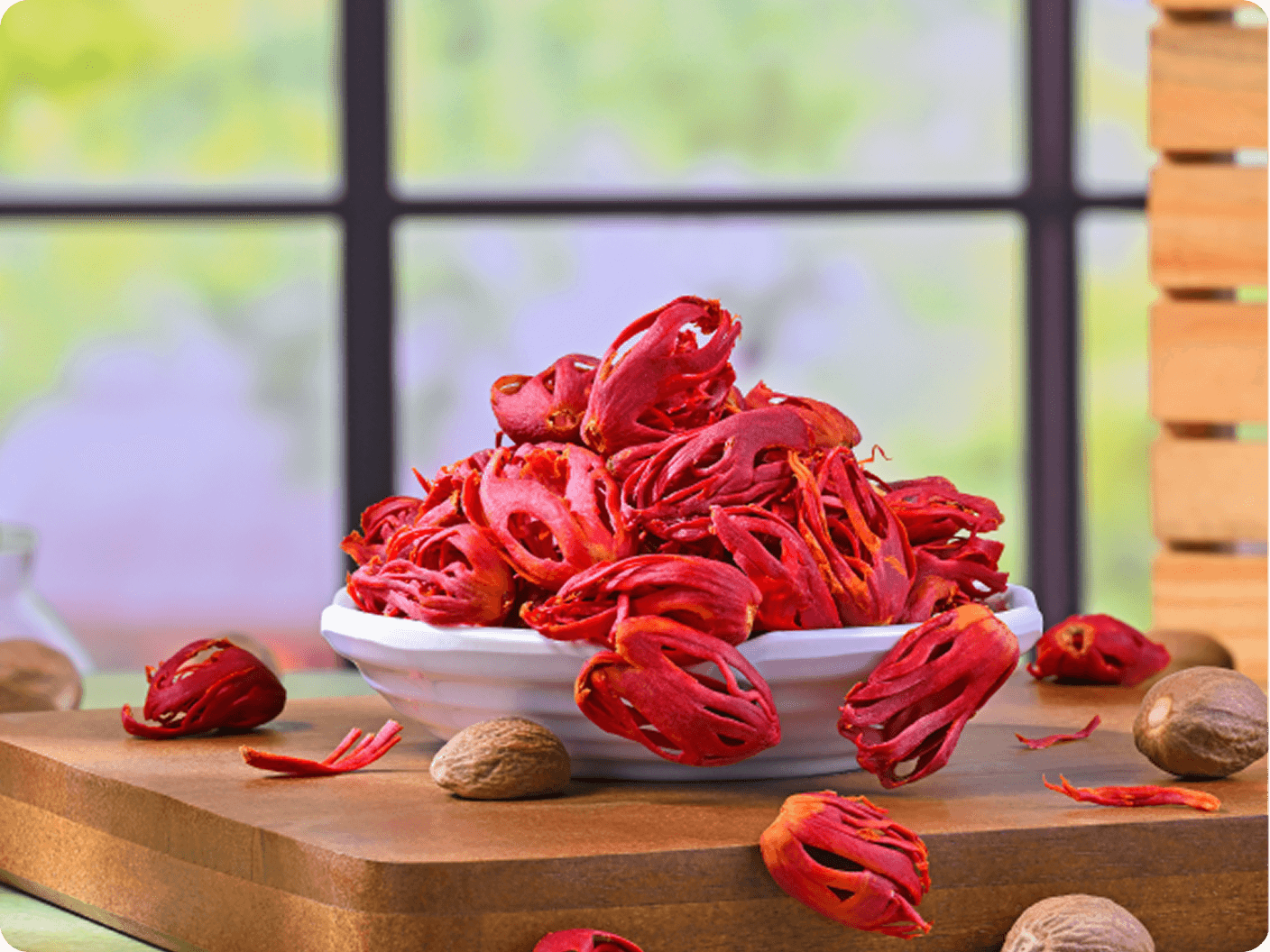 Red mace spice in a white bowl on a wooden board
